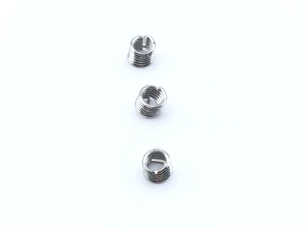 three metal hex nuts arranged in a triangular pattern with inserts and wire linecard on a white background.