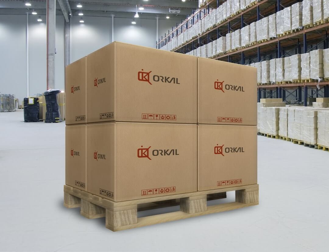 a stack of large cardboard boxes marked "orkal" on a wooden pallet in a warehouse with shelves stocked in the background.