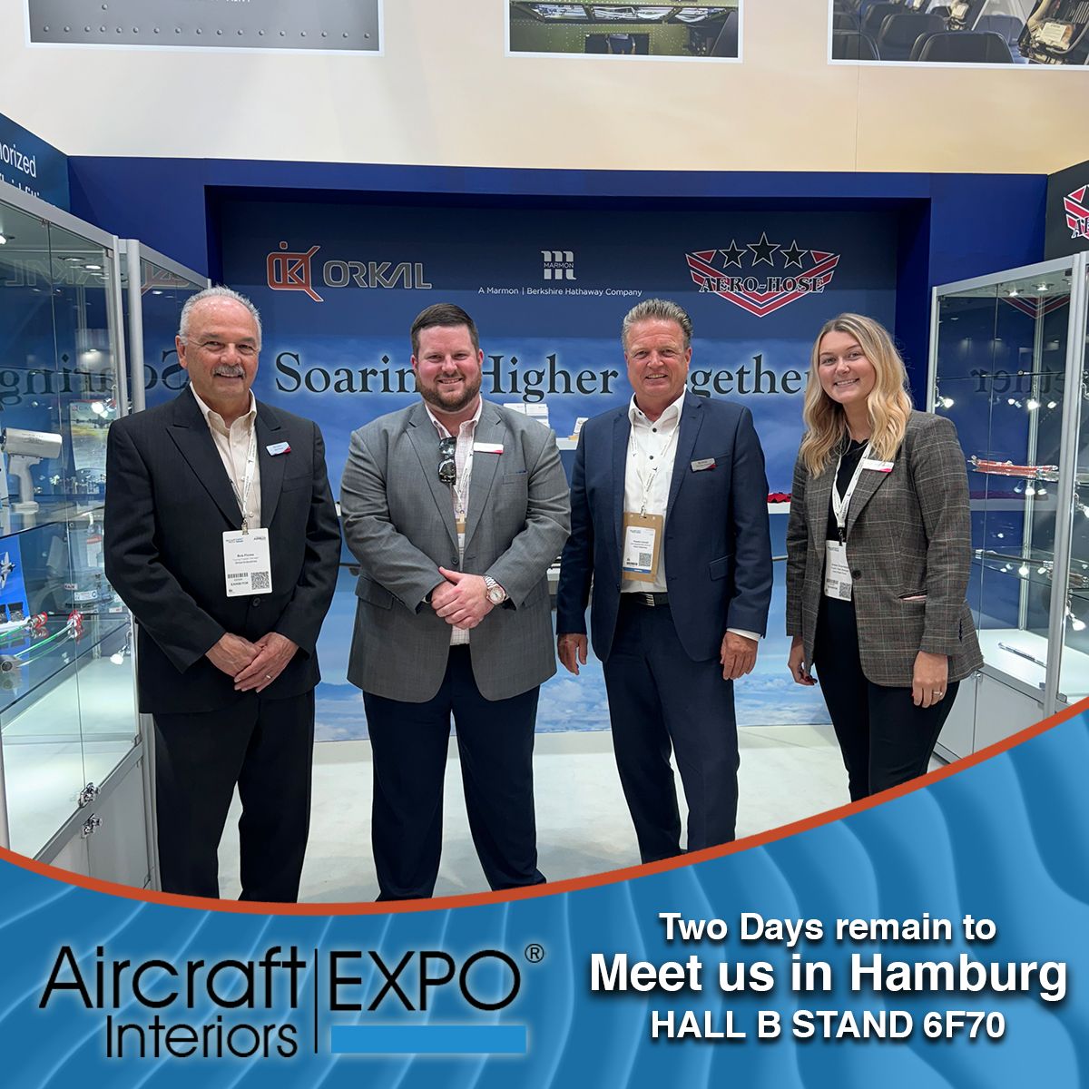 orkal, four individuals stand before "soaring higher together." orkal industries at aircraft interiors expo, hall b stand 6f70.
